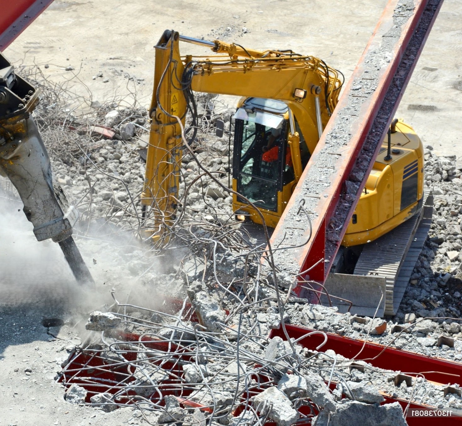 Abbruchbagger und Hydraulikhammer beim Abbruch von Stahlbeton